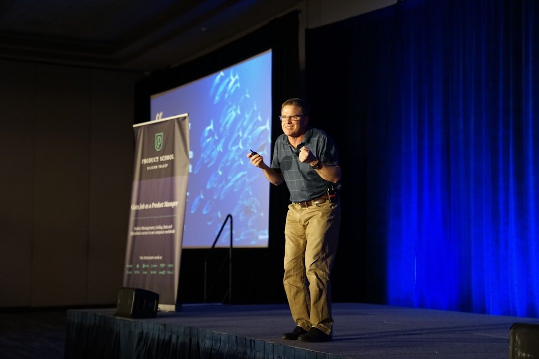 Speaker on a keynote conference stage addressing the audience