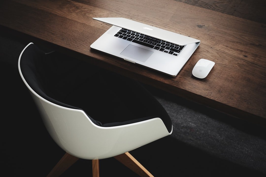 Minimalist workspace with a laptop and chair at a wooden desk