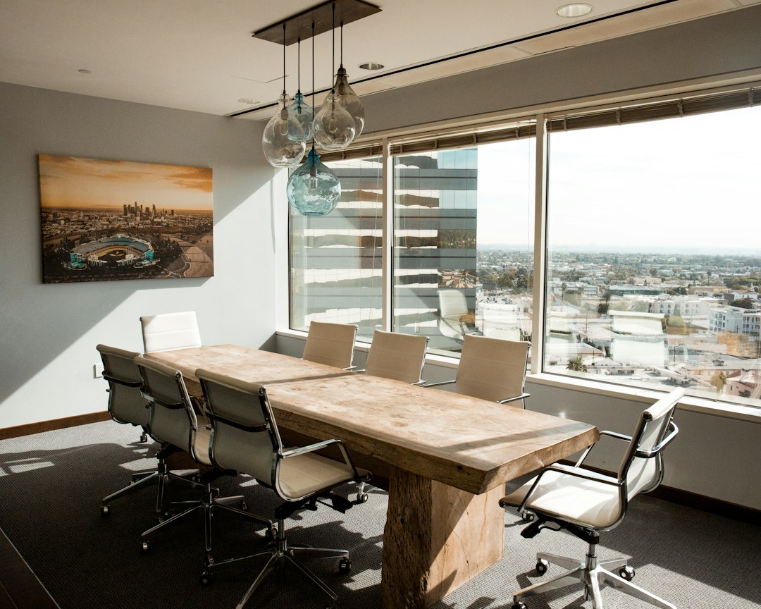 A bright, empty conference room with white chairs and tall windows, ready for a Google Slides presentation that looks good on the big screen
