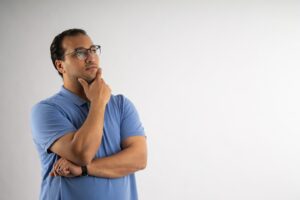 Man resting his chin on his hand, thinking through presentation topics before choosing one