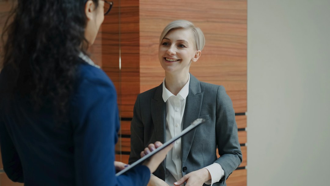 Two colleagues talking face to face in an office, trading ideas for presentation topics at work